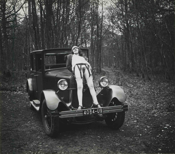 coquine non épilée nue pose sur une auto rétro dans la forêt